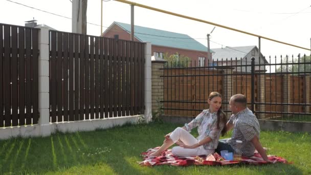 женщина и красивый мужчина сидят во дворе и сын прыгает на мать
 - Кадры, видео