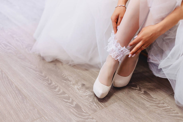 the bride wears shoes on a wedding morning - Fotografia, imagem