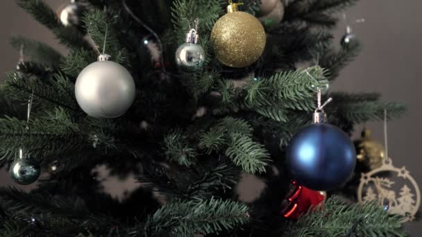 kunstmatige kerstboom met glanzende slingers in duisternis - Video