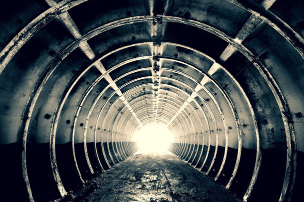Absztrakció a háttérben. A végén a gyűrű alakú merev bordákkal és fényes fénnyel rendelkező alagút. Beton katonai építése. Fekete-fehér. Színezett. - Fotó, kép