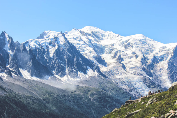 Pessoas no topo de uma rocha com vista para o incrível Monte Blanc, perto de Chamonix, em Alpes Franceses. O pico mais alto da França e da Europa. Temporada de verão. Caminhantes conceito de aventura. Destinos turísticos
 - Foto, Imagem