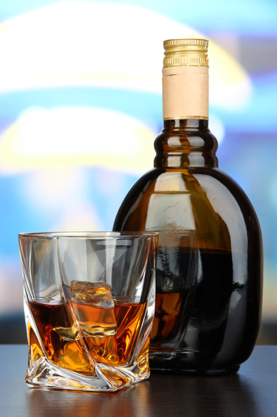 Glass of liquor with bottle, on dark background - Photo, Image