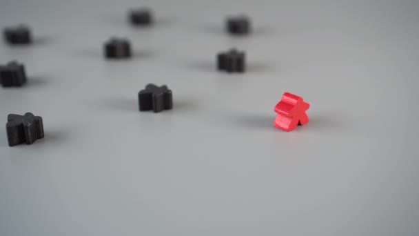 A mão remove a figura vermelha do ambiente de figuras pretas em uma superfície cinza. O conceito da demissão do líder da equipe
 - Filmagem, Vídeo