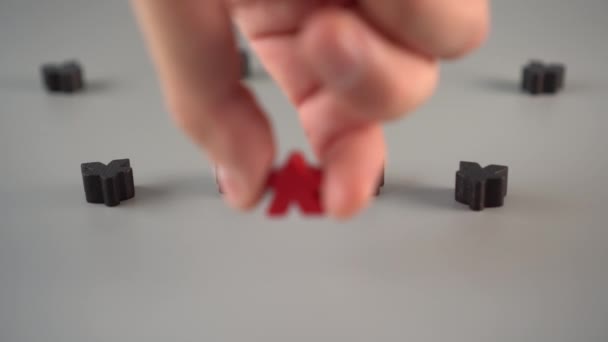 Een hand wordt een rode figuur, omringd door zwarte figuren op een grijs oppervlak. Team Leader concept - Video