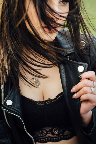 Girl in a black leather jacket walks through the city - Фото, изображение