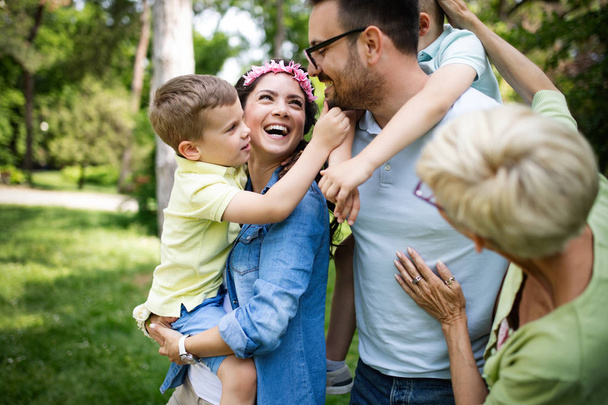 Familia feliz con niños disfrutando de un día de verano juntos al aire libre
 - Foto, Imagen