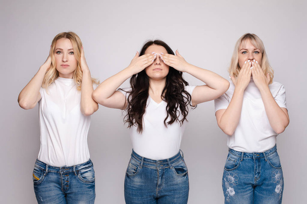 Trois jeunes femmes cachant différentes parties de leur visage
. - Photo, image