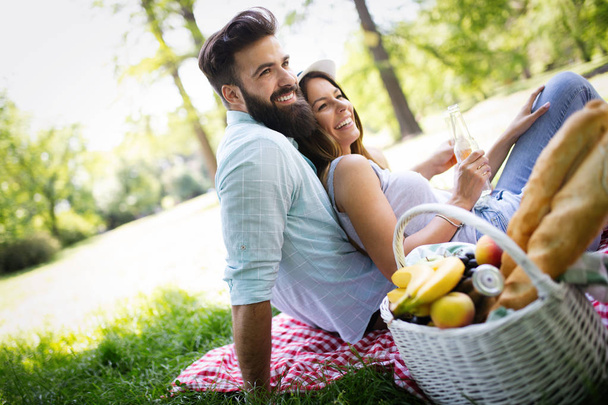 Happy couple in love enjoying picnic time outdoors - Photo, image