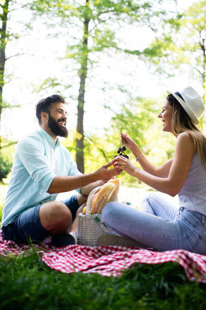 Happy couple in love enjoying picnic time outdoors - Фото, изображение