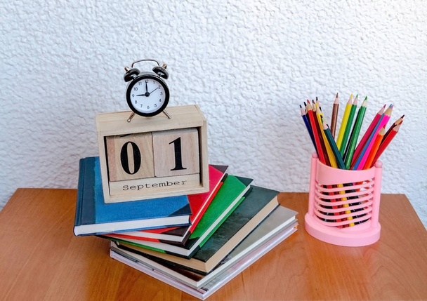 calendario con la fecha del primero de septiembre y un reloj despertador, lápices de color sobre la mesa
 - Foto, imagen