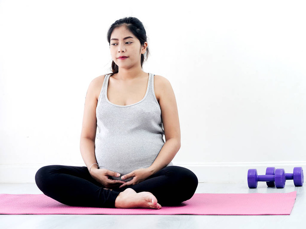 Asiática embarazada haciendo meditación en casa, estilo de vida concepto
. - Foto, Imagen