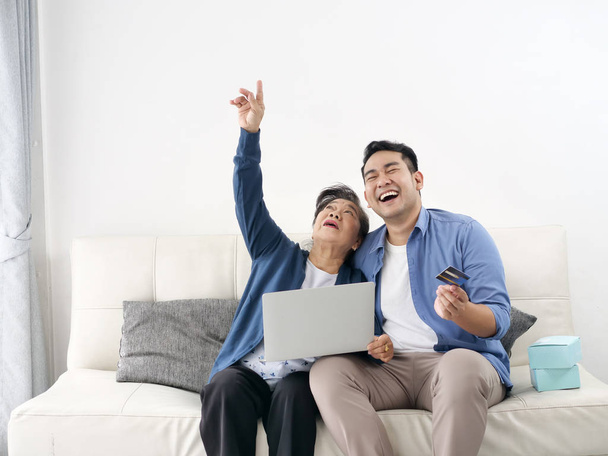 Asian man teaching his mother for shopping online, modern lifest - Valokuva, kuva