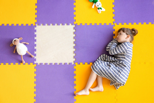 Petite fille avec trouble autistique couchée sur le sol, vue de dessus - Photo, image
