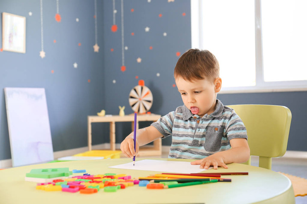 Kleine jongen met autistische stoornis in de speelkamer - Foto, afbeelding