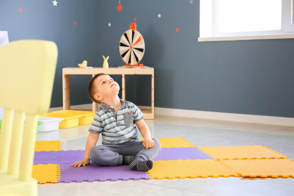 Mały chłopiec z zaburzeniami autystycznych w pokoju zabaw - Zdjęcie, obraz