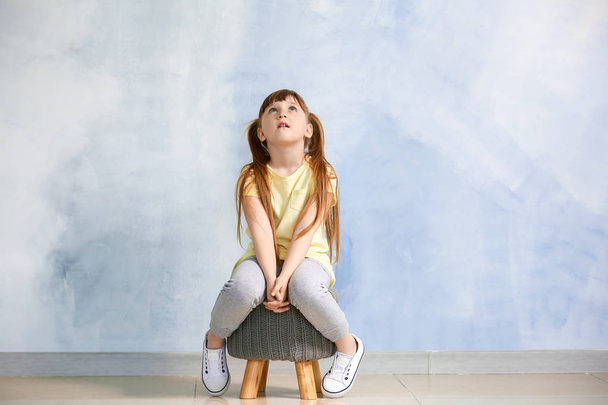 Niña con trastorno autista sentada cerca de la pared de luz
 - Foto, Imagen