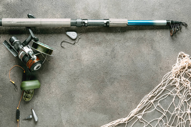 Fishing tackle, net and accessories on grey background - Foto, immagini