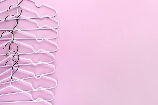 Many clothes hangers on color background - Photo, Image