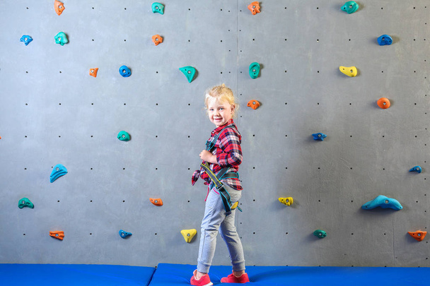 Spor salonunda tırmanma duvarı yakınında küçük kız - Fotoğraf, Görsel