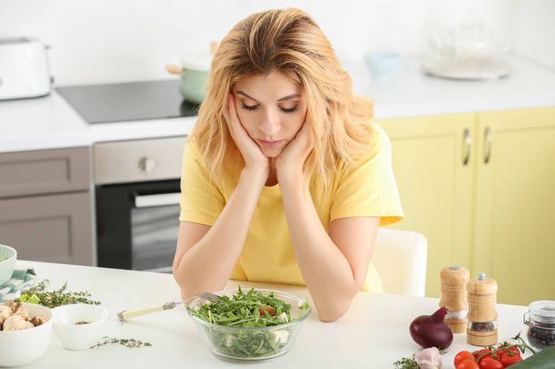 Zdráhavá žena se zdravým zeleninovým salátem v kuchyni - Fotografie, Obrázek
