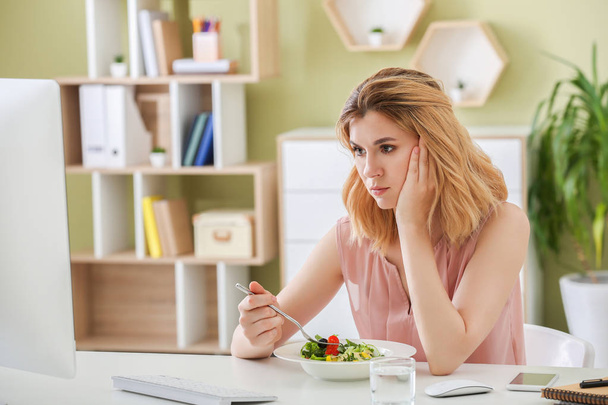 Ofiste sağlıklı sebze salatası ile isteksiz kadın - Fotoğraf, Görsel