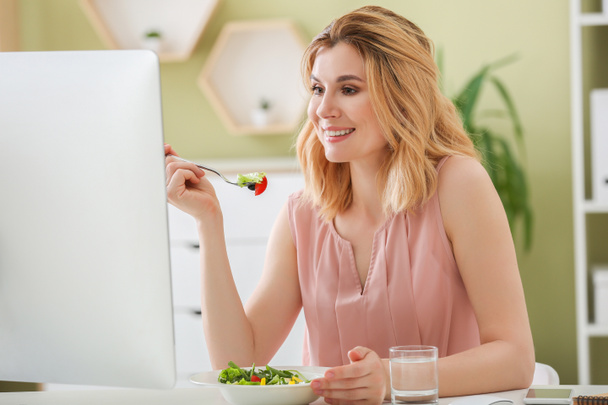 Woman eating healthy vegetable salad in office - Photo, Image