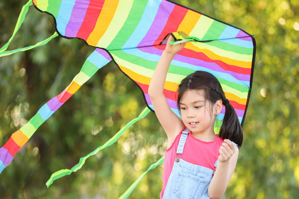Little girl flying kite outdoors - Фото, зображення