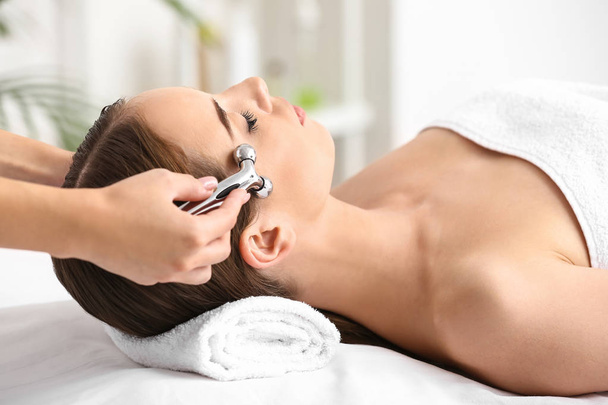 młoda kobieta mając masaż twarzy w salonie piękności - Zdjęcie, obraz