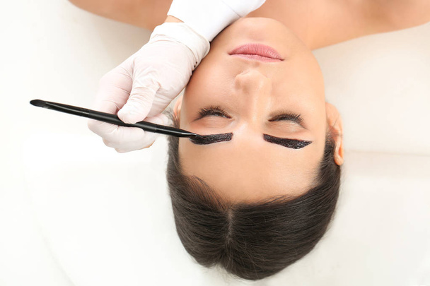 Jeune femme subissant une procédure de correction des sourcils dans un salon de beauté - Photo, image