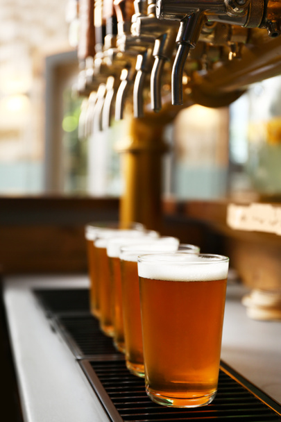 Γυαλιά φρέσκου ΒΑΡΕΛΙ μπύρας σε πάγκο μπαρ - Φωτογραφία, εικόνα