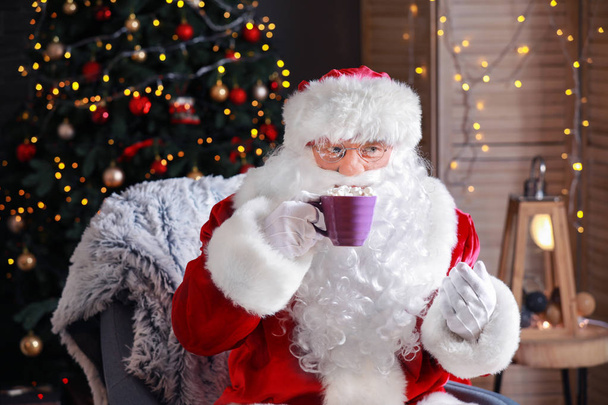 Santa Claus drinken warme chocolademelk op kerstavond - Foto, afbeelding