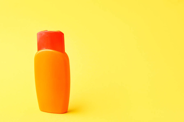 Bottle of sun protection cream on color background - Valokuva, kuva