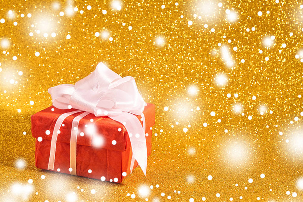 Caja de regalo sobre fondo dorado
 - Foto, imagen