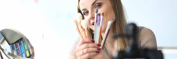 女性のVloggerはVlogのための化粧品の用具を提示する - 写真・画像