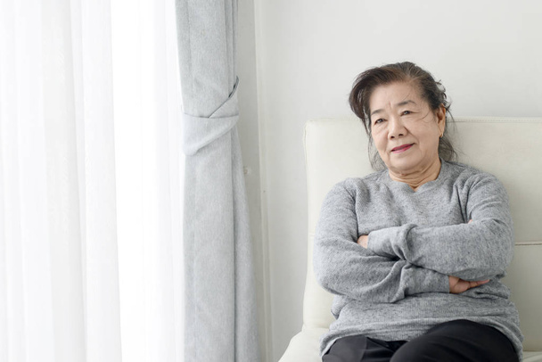 Happy Asian senior woman relaxing on sofa at home, lifestyle con - Foto, afbeelding