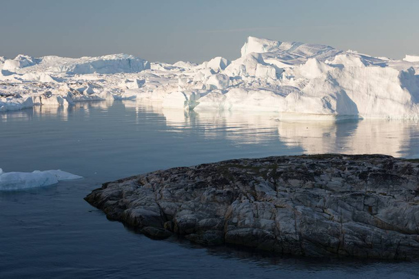 Grönlannin tai Etelämantereen luonto ja maisemat. Matkustaa aluksella jäällä. Ilmaston lämpenemisen ilmiön tutkiminen Jäät ja epätavalliset muodot ja värit Kaunis aurinkoinen ja pilvinen päivä
  - Valokuva, kuva