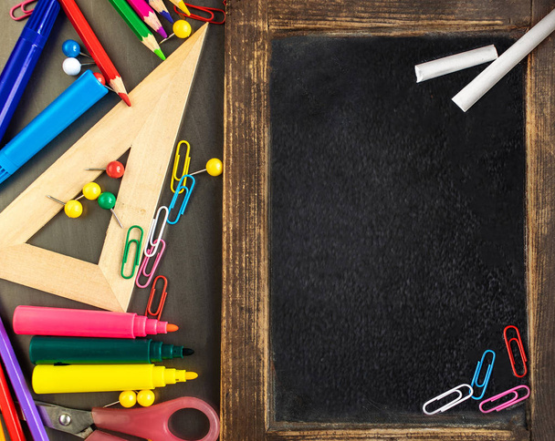 School supplies on black board background with Stationery. Back  - Foto, afbeelding