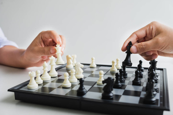 hand of businessman moving chess in competition, shows leadership, followers and business success strategies - Photo, image