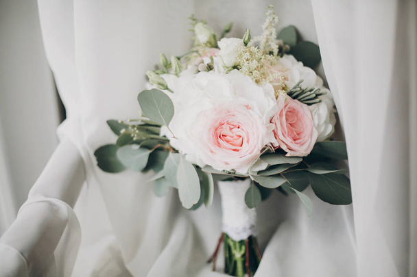 Stylish Modern wedding bouquet on white tulle in soft light in h - Фото, зображення