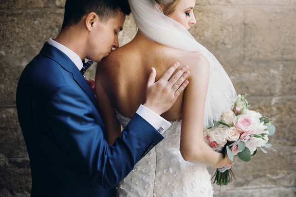 Stílusos vőlegény óvatosan csókolózás gyönyörű menyasszony csokor SHO - Fotó, kép