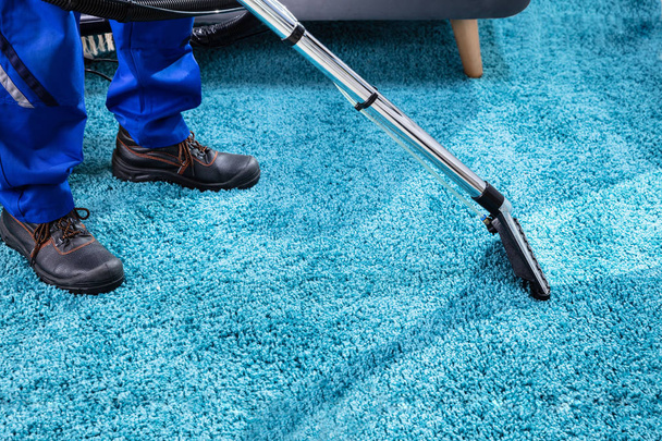 Close-up Of A Person Cleaning Carpet With Vacuum Cleaner - Foto, immagini