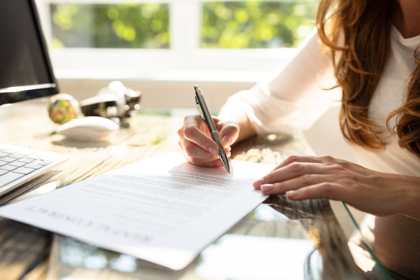 Крупним планом контракт підписання руки бізнес-леді з ручкою над робочим столом в офісі
 - Фото, зображення