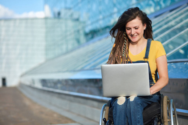 happy cute businesswoman in wheelchair working using a laptop - Zdjęcie, obraz