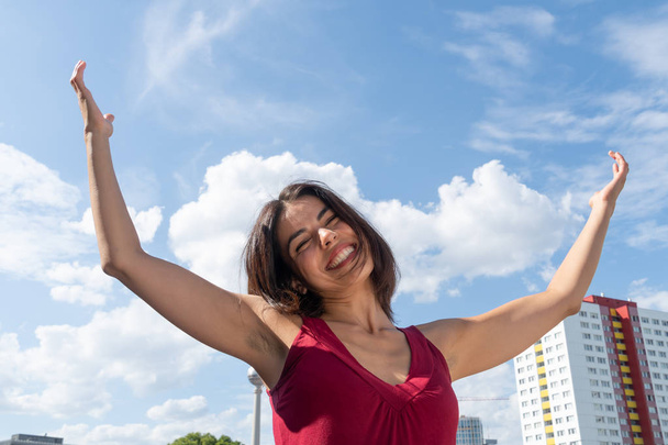 Zalige vrouw die met uitgestrekte armen het stadsbeeld van Berlijn viert - Foto, afbeelding