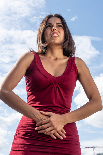 Stomach ache. Young brunette woman suffering with menstrual or abdominal pain - Photo, Image