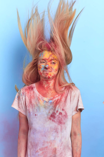 tired girl with flying colored hair, body and clothes after Holi Color festival - 写真・画像