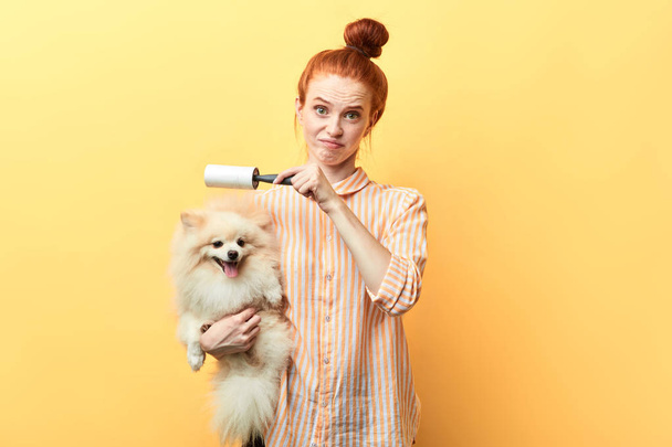 ginger attractive girl using lint roller - Photo, Image