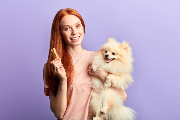 pleasant cheerful girl giving vitamins to her pet - Zdjęcie, obraz