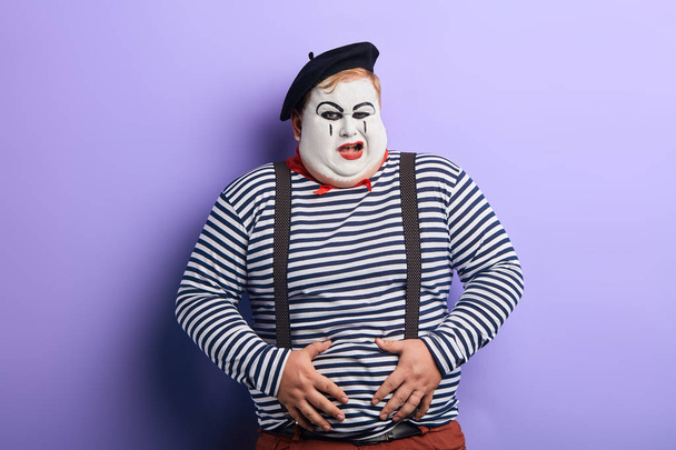 crazy funny plump clown having a problem with his stomach - Foto, imagen