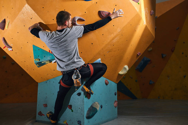 Flexible athletic climber without forearm training hard in bouldering gym - Fotografie, Obrázek